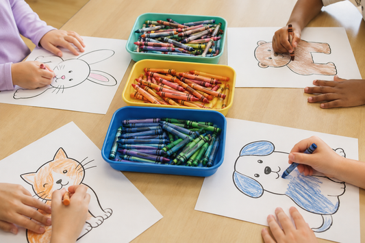 Children coloring large animal pages with crayons organized in trays